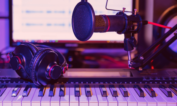 Rapper-and-producer-headphones-microphone-and-midi-keyboard-in-home-studio